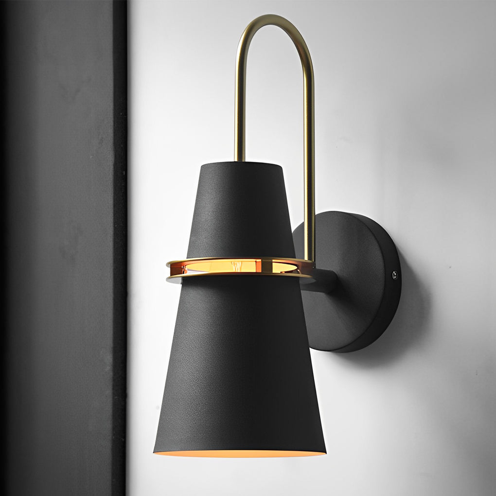 Close-up view of black cone wall lamp showing curved brass arm and matte texture.