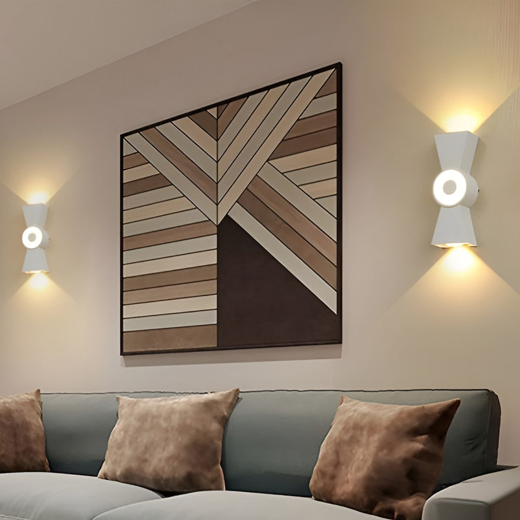 Contemporary up down wall lights providing soft illumination beside a bookshelf.