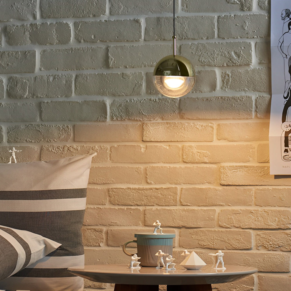 Small globe pendant light illuminating a cozy bedroom corner with figurines and brick wall.