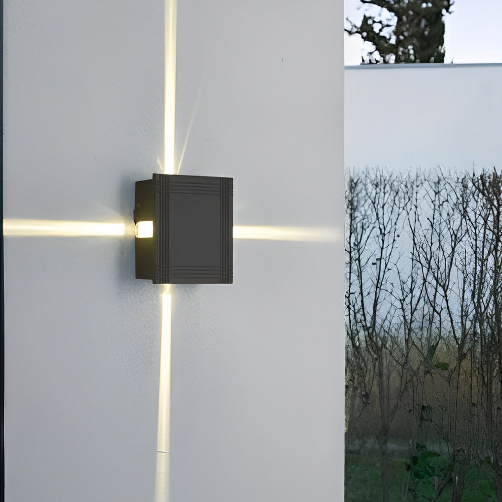 Cross light beams wall sconce casting a gentle X-shaped glow on a white exterior wall.