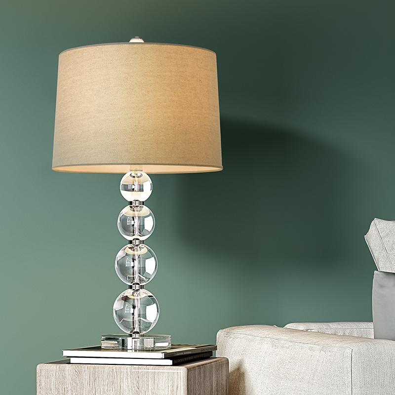 Crystal ball table lamp illuminated on a bedside table with soft ambient light.