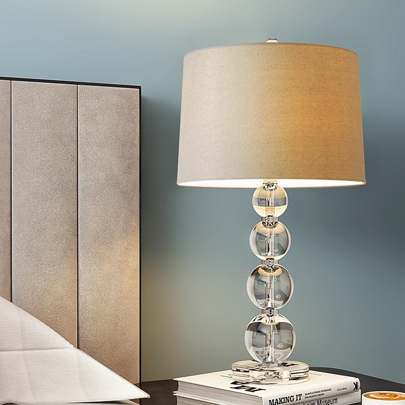 Crystal ball table lamp displayed on a nightstand with decorative books.