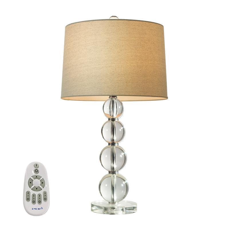 Crystal ball table lamp isolated with remote control on a white background.