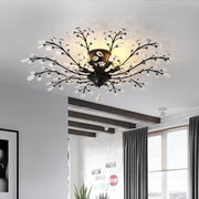 Crystal branch chandelier mounted on white ceiling in modern interior.
