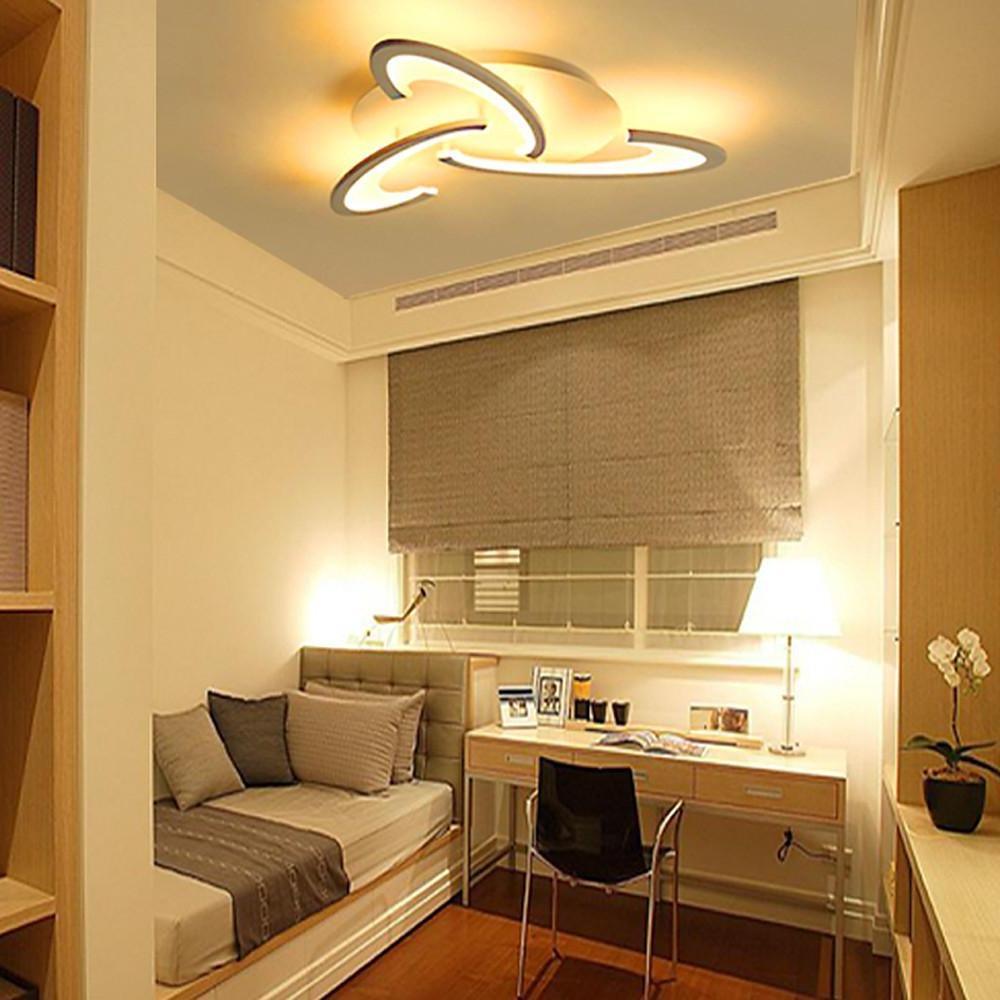 Curved LED ceiling light used in a compact bedroom workspace.