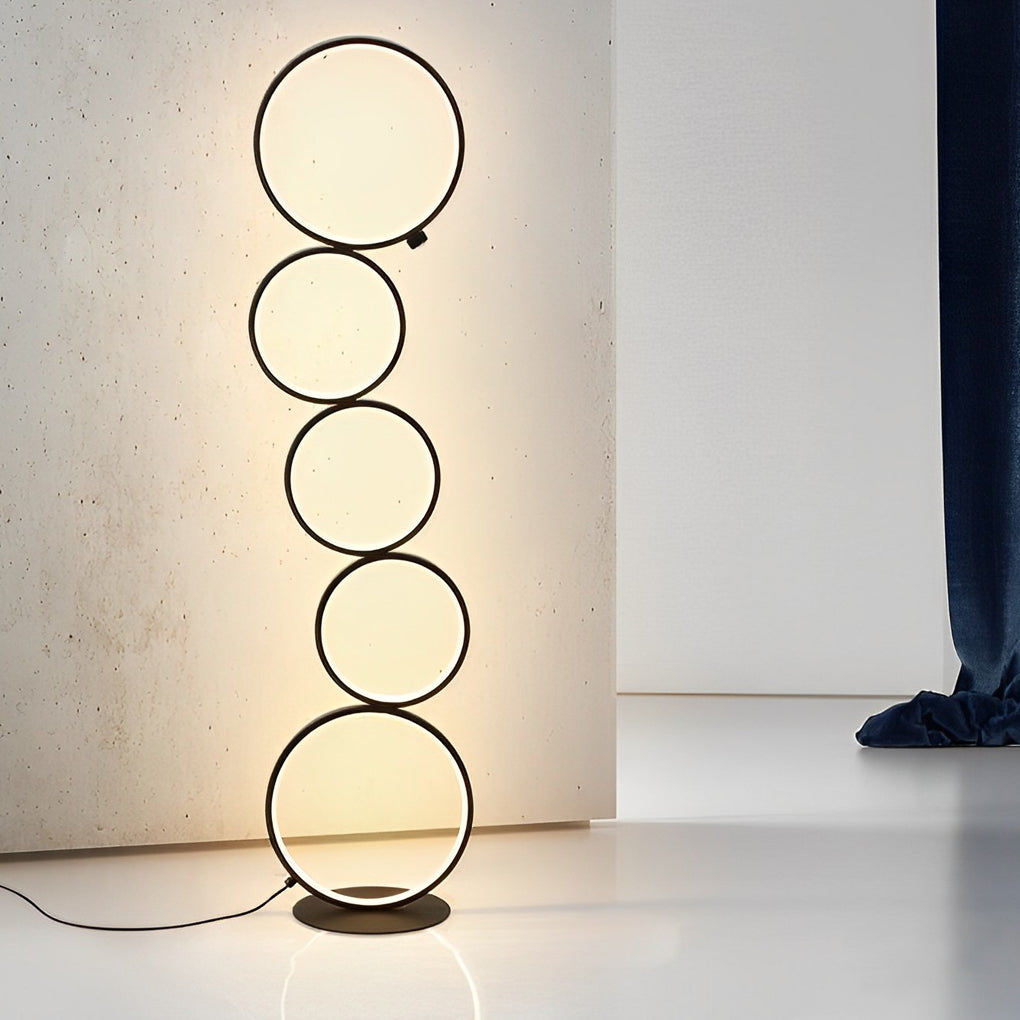 Decorative floor lamps with circular LED rings, creating a warm atmosphere in a living room with yellow sofa.
