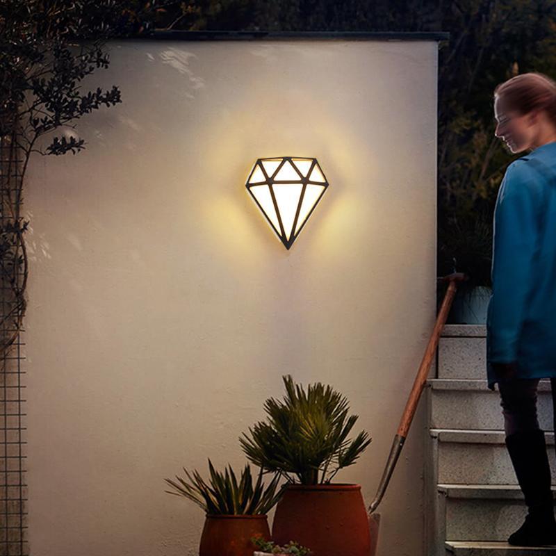 Diamond shape wall light with a geometric design, mounted on a white wall.
