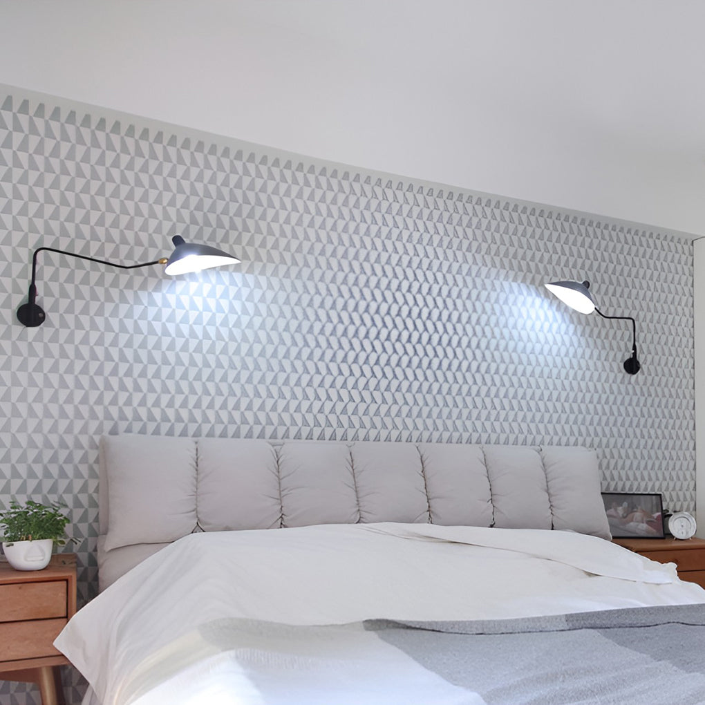 Double arm wall sconce positioned above a bed, delivering focused reading light with adjustable swing arms.