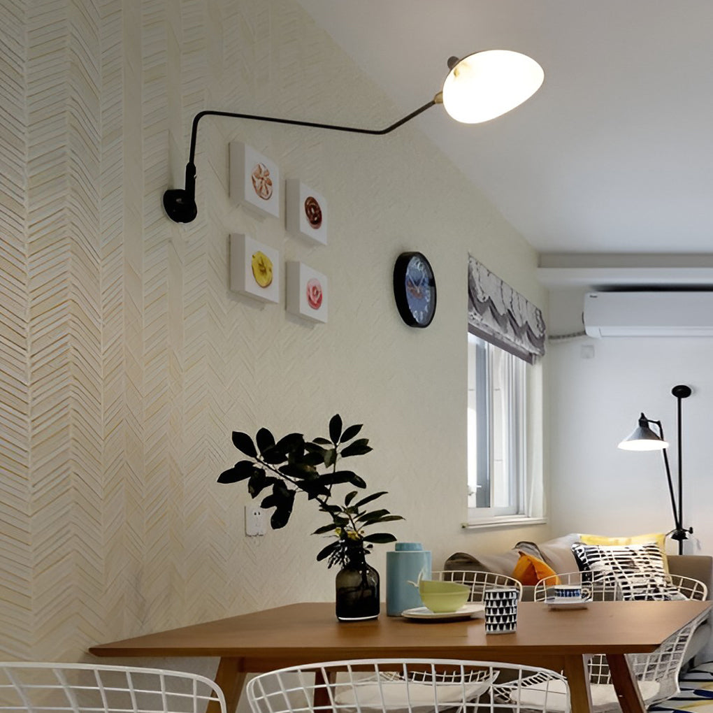 Double arm wall sconce above a dining table, providing directional lighting for a cozy modern dining space.