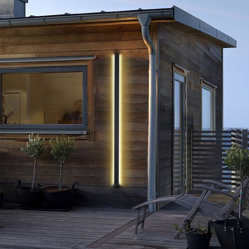 Double long black outdoor lights mounted symmetrically on a modern facade, offering stylish and warm illumination.