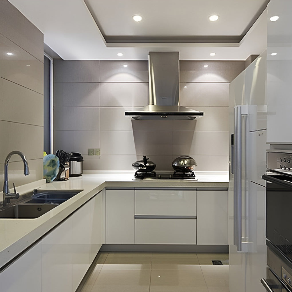 Contemporary kitchen designed with bright elite lighting can lights above work surfaces.