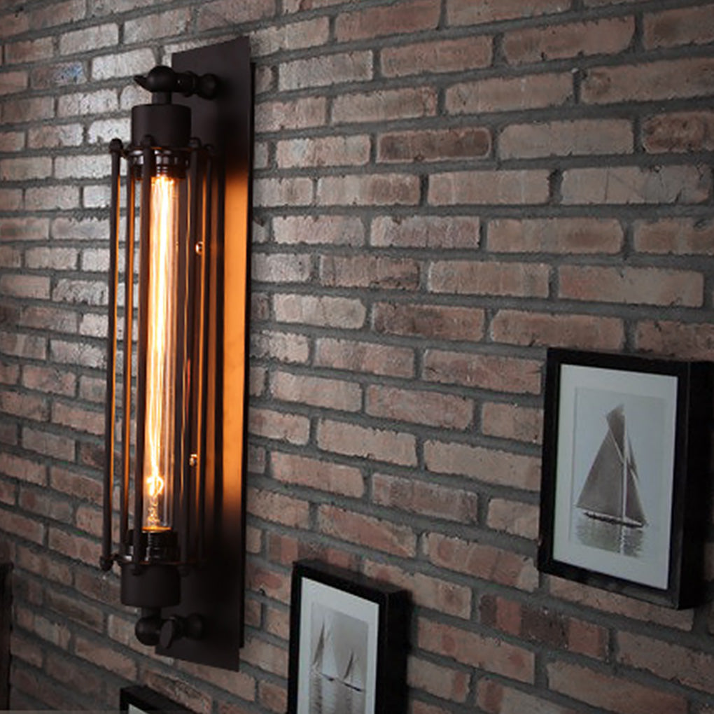 Vintage industrial wall sconce with exposed bulb, installed on brick wall beside framed art for rustic charm.