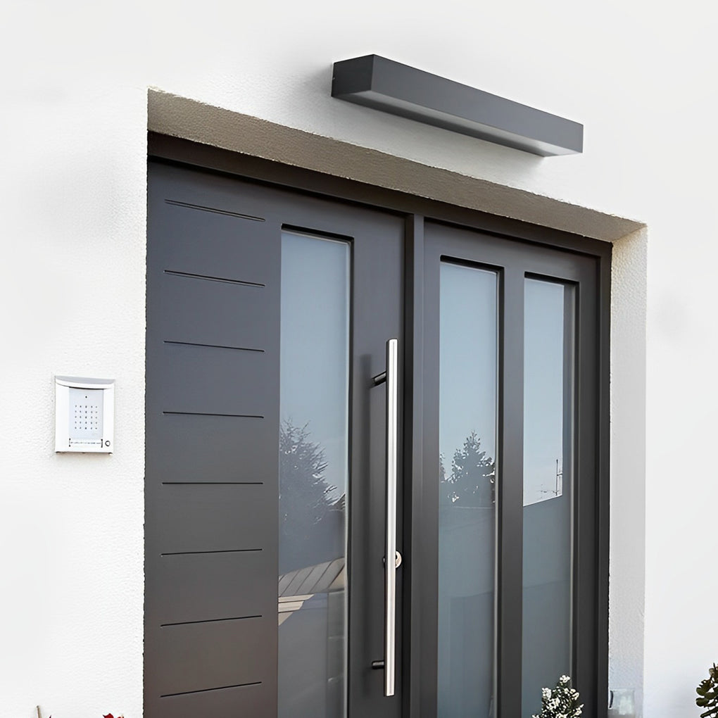 Linear exterior porch light fixtures installed above double entry doors in modern home exterior.