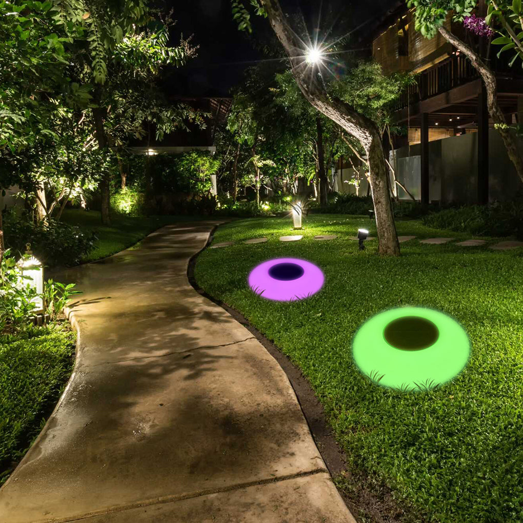 Floating pond lamps lighting a garden walkway at night
