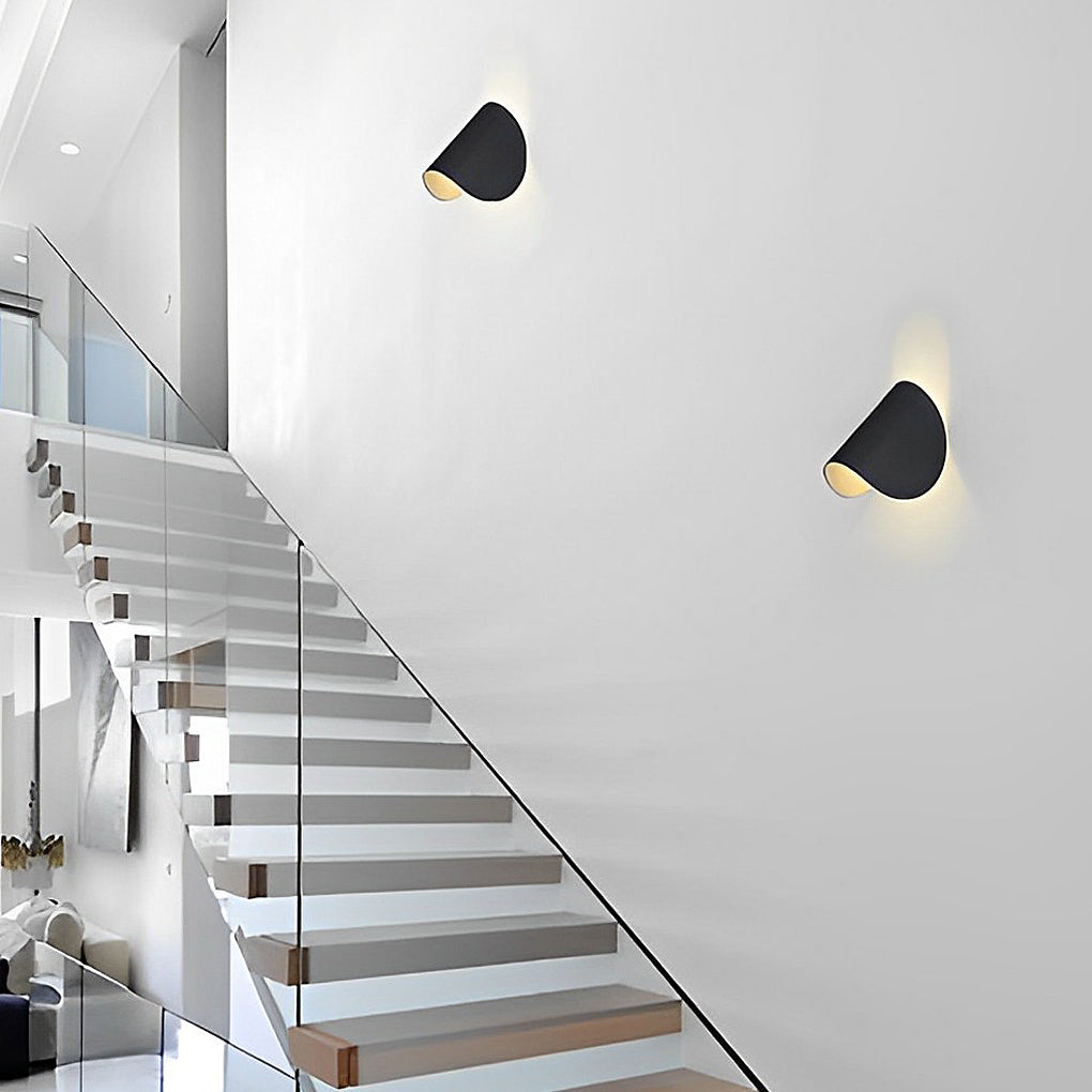 Folding wall sconce illuminating a minimalist interior with focused glow.