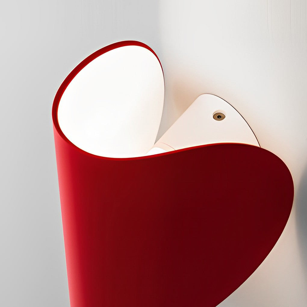 Folding wall sconce in red enhancing a modern bedroom with warm light.