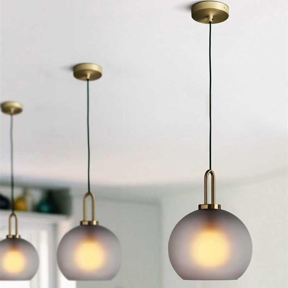 Frosted glass mini pendant lights illuminating a modern kitchen with elegant light.