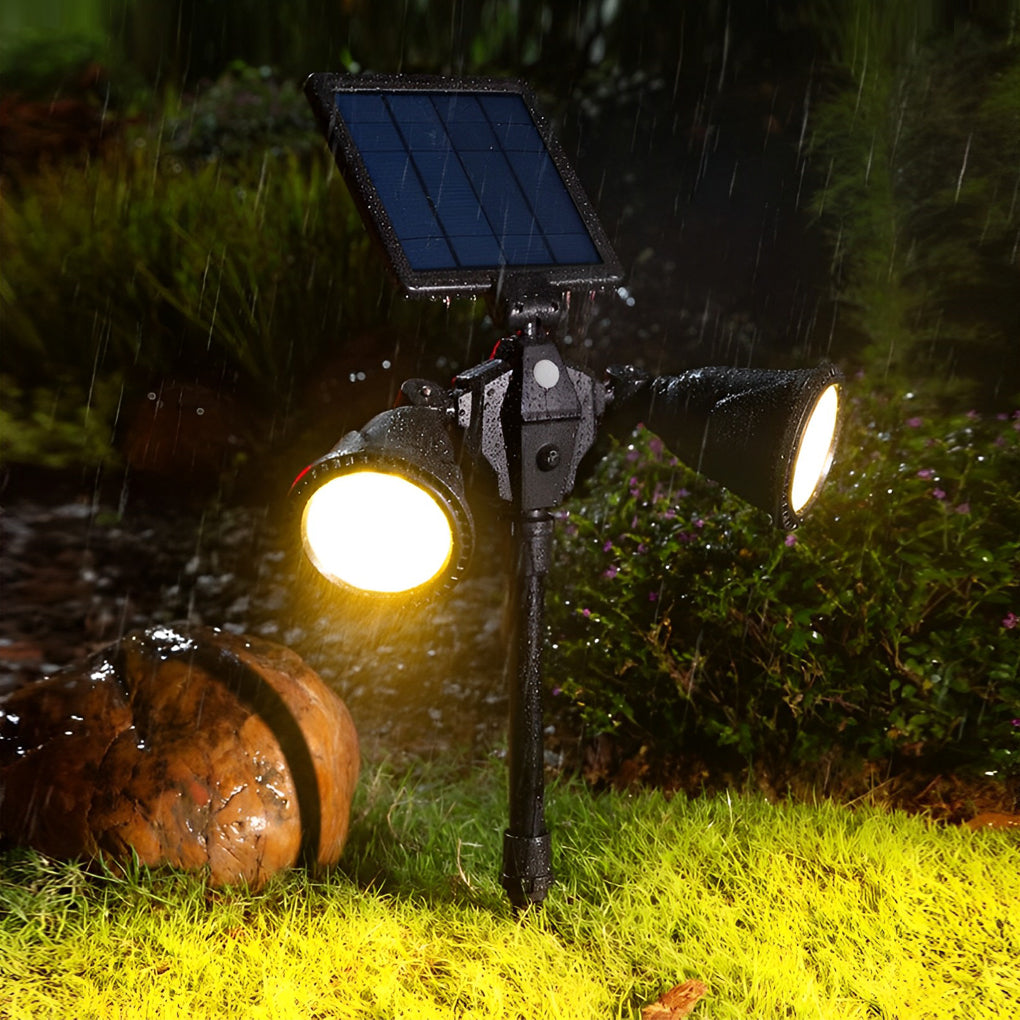 Garden spotlights solar powered providing warm light beside a garden pathway.