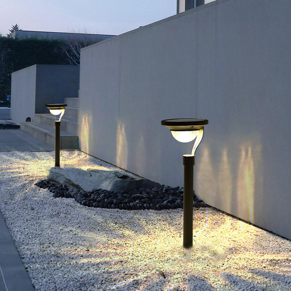 Garden stake solar lights providing ambient light in a lush green lawn.