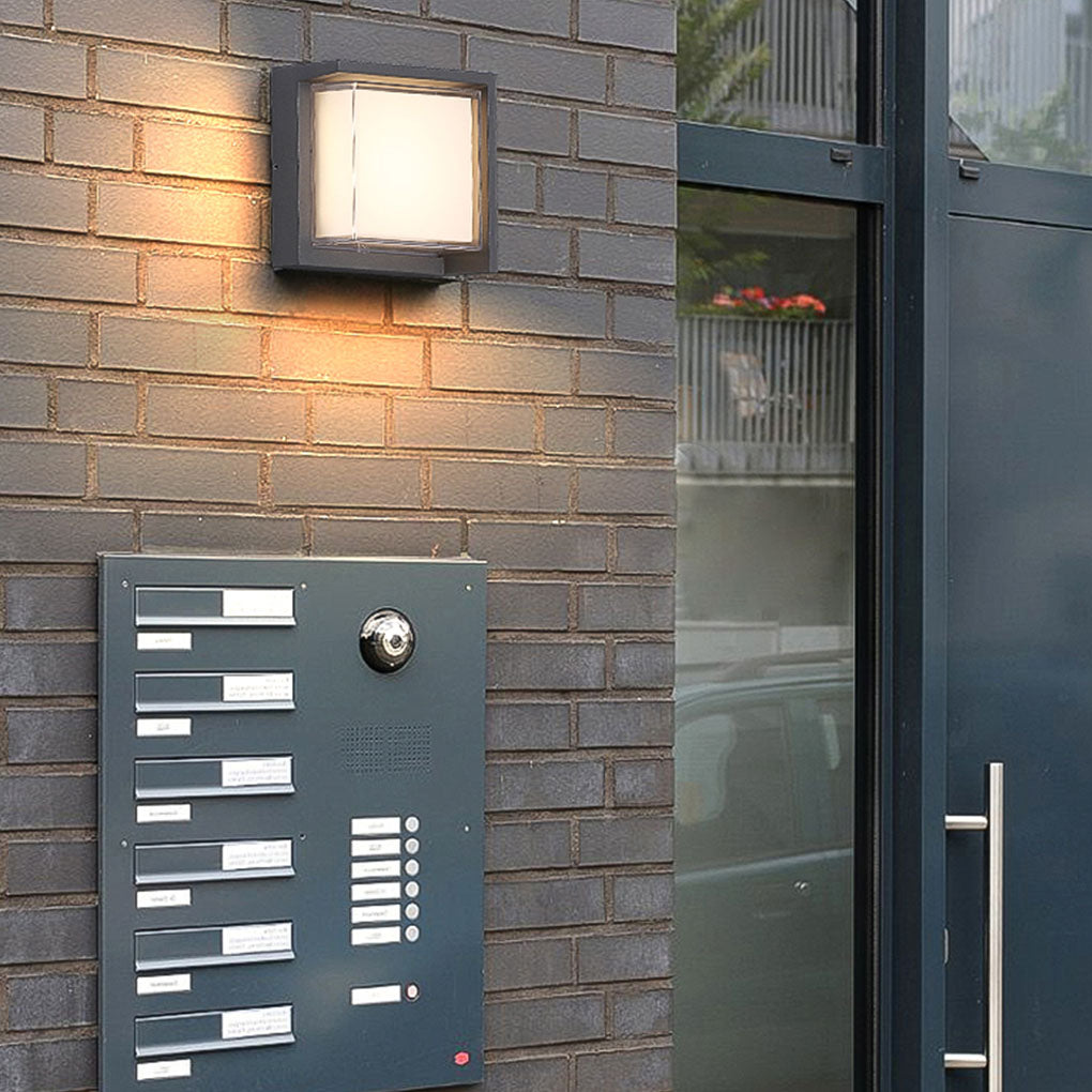 Geometric outdoor sconce providing soft illumination near a minimalist door.