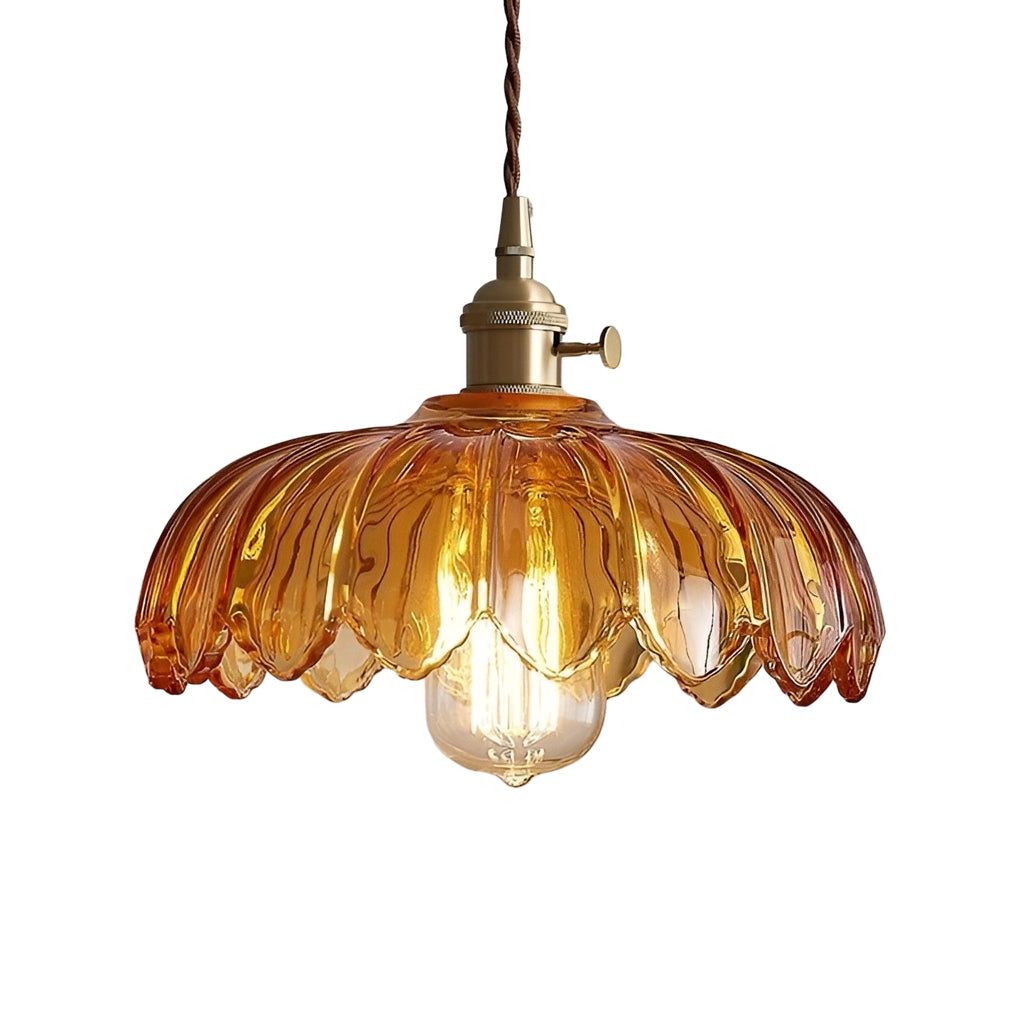 Amber glass pendant light isolated on white background, featuring scalloped edges and classic brass suspension.