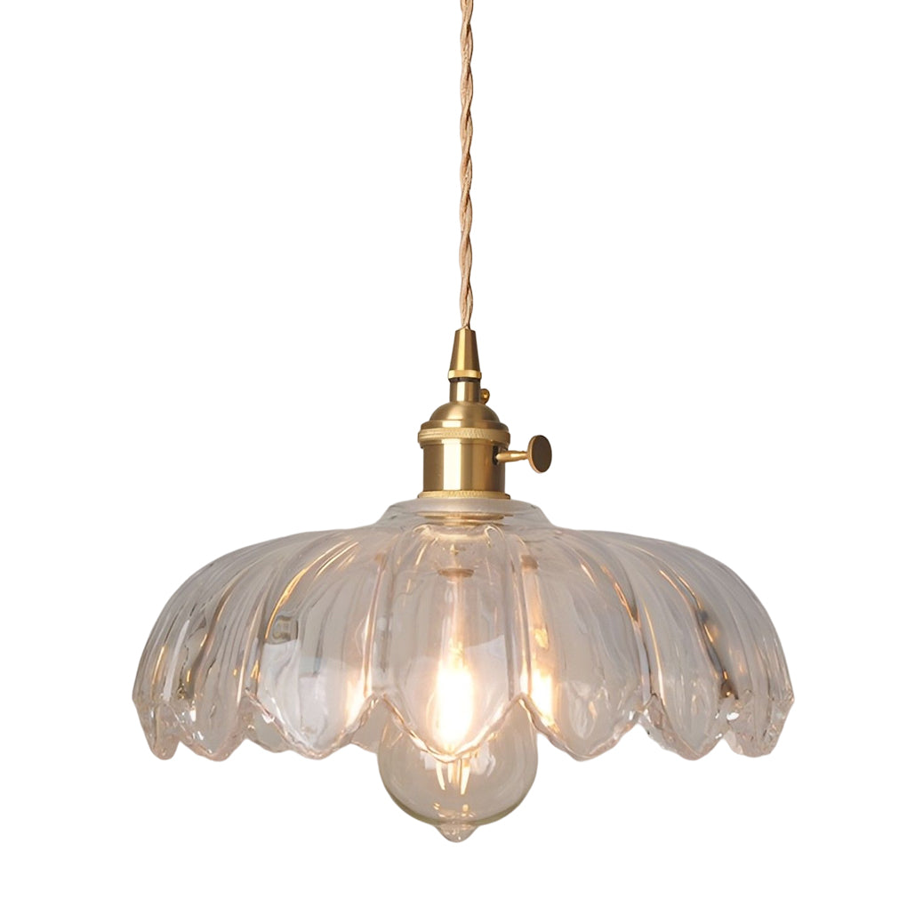 Single clear glass pendant light isolated on white background with brass fixture and softly lit bulb.