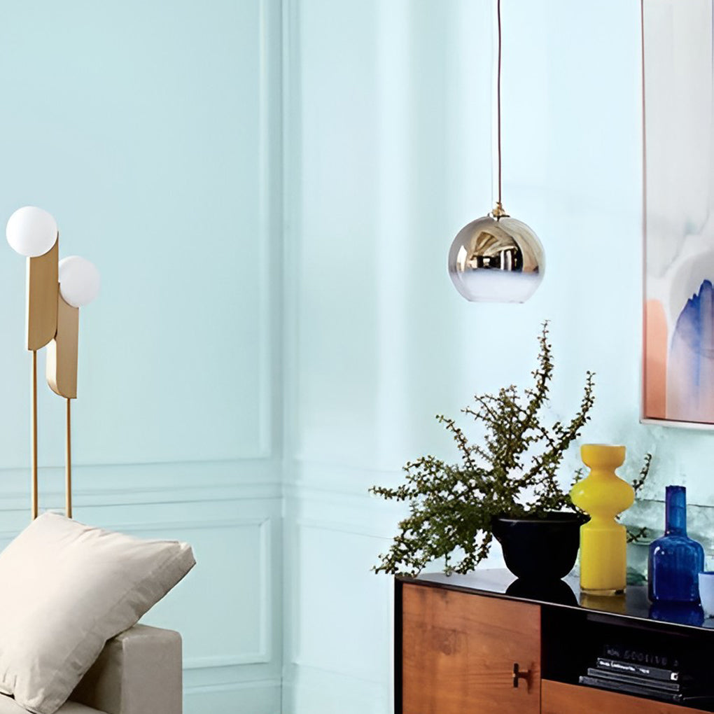 Two glass round pendant lights installed symmetrically above a counter.