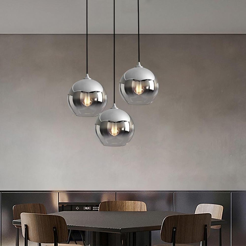 Glass round pendant light illuminating a modern living room space.