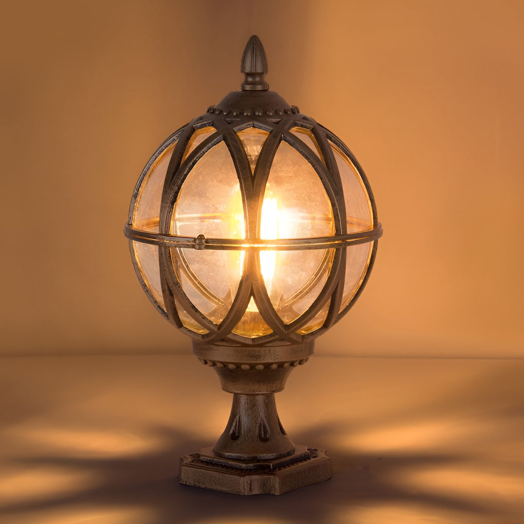 Globe pillar lights with intricate bronze frame, close-up of illuminated glass globe.