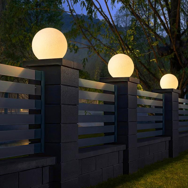 Modern globe pillar lights lining a garden fence