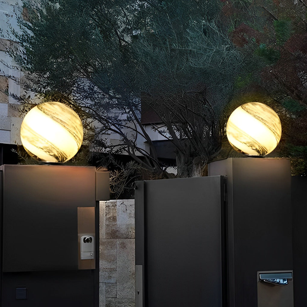 Globe pillar lights casting warm glow on outdoor steps and plants.