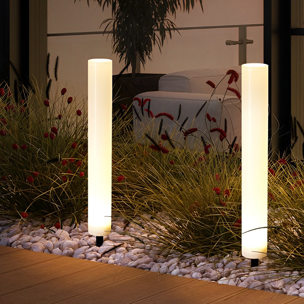 Glowing pillar light illuminating a minimalist outdoor garden with focused glow.