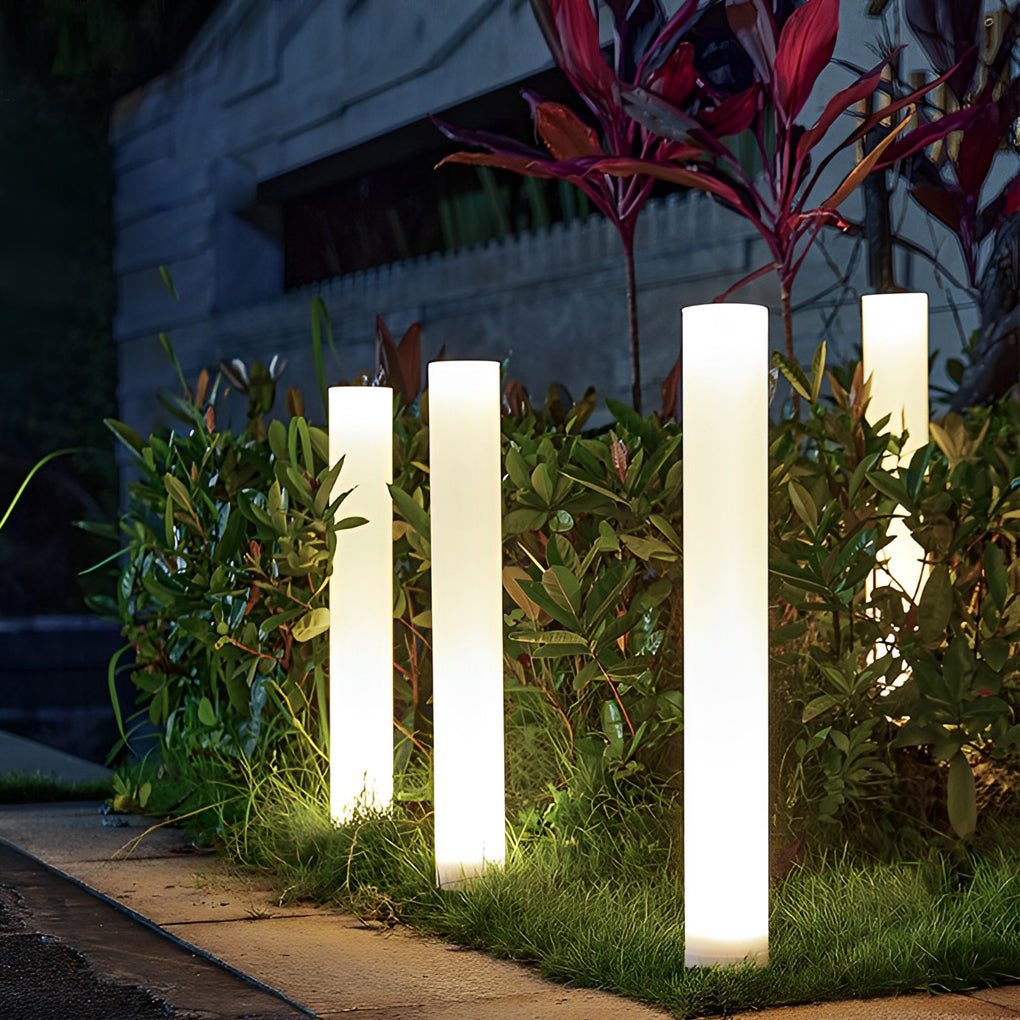 Glowing pillar light enhancing a modern outdoor seating area with warm light.