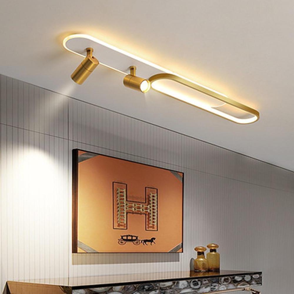 Gold adjustable ceiling spotlights paired with oval LED ceiling light in living space.