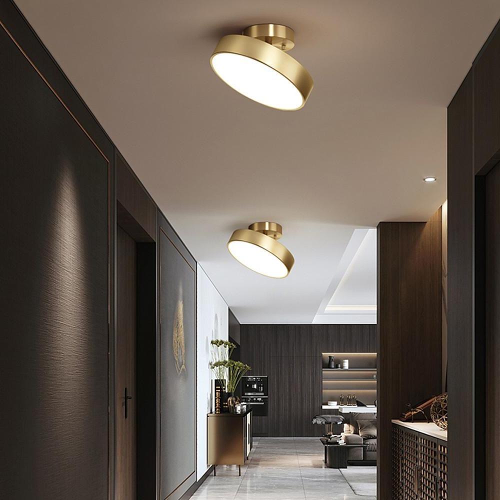 Gold adjustable LED ceiling light mounted in a contemporary hallway ceiling.
