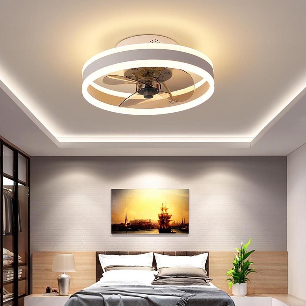 Gold ceiling fan with integrated LED light above bed in modern bedroom.