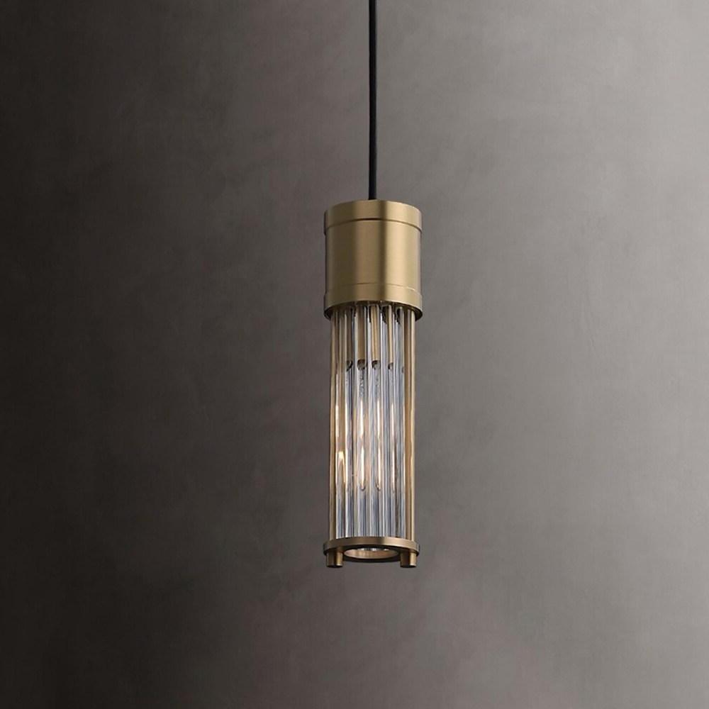 Close-up view of gold cylinder pendant light illuminated.
