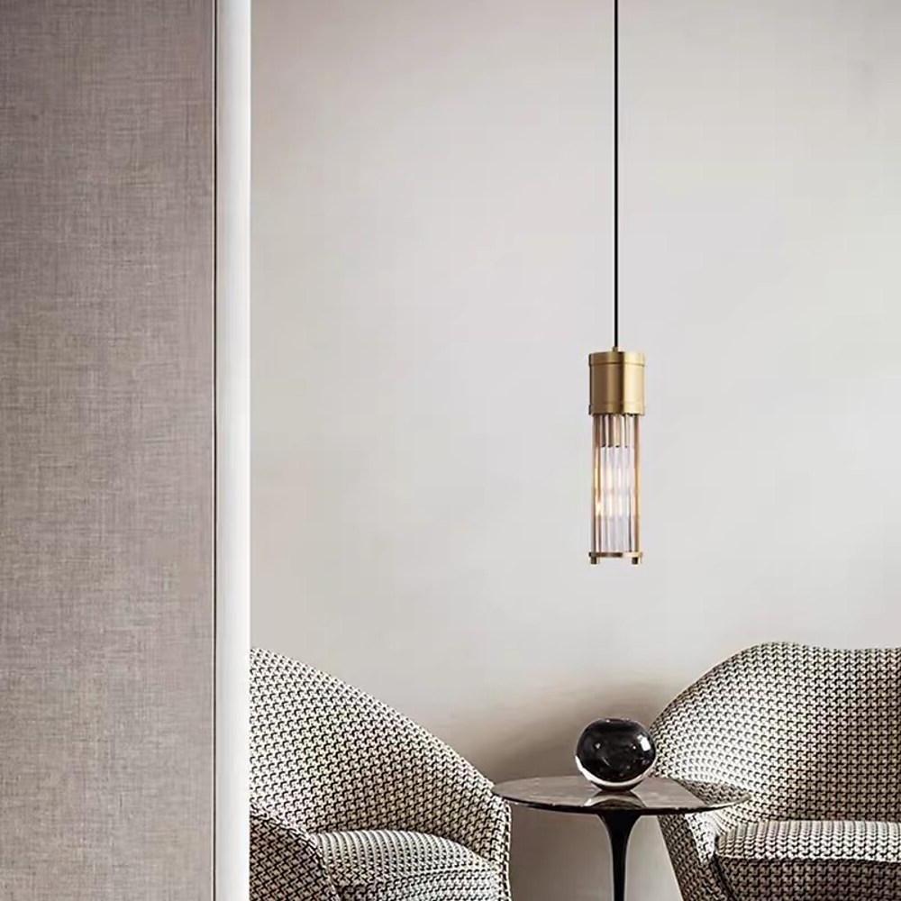 Gold cylinder pendant light with ribbed glass shade detail.