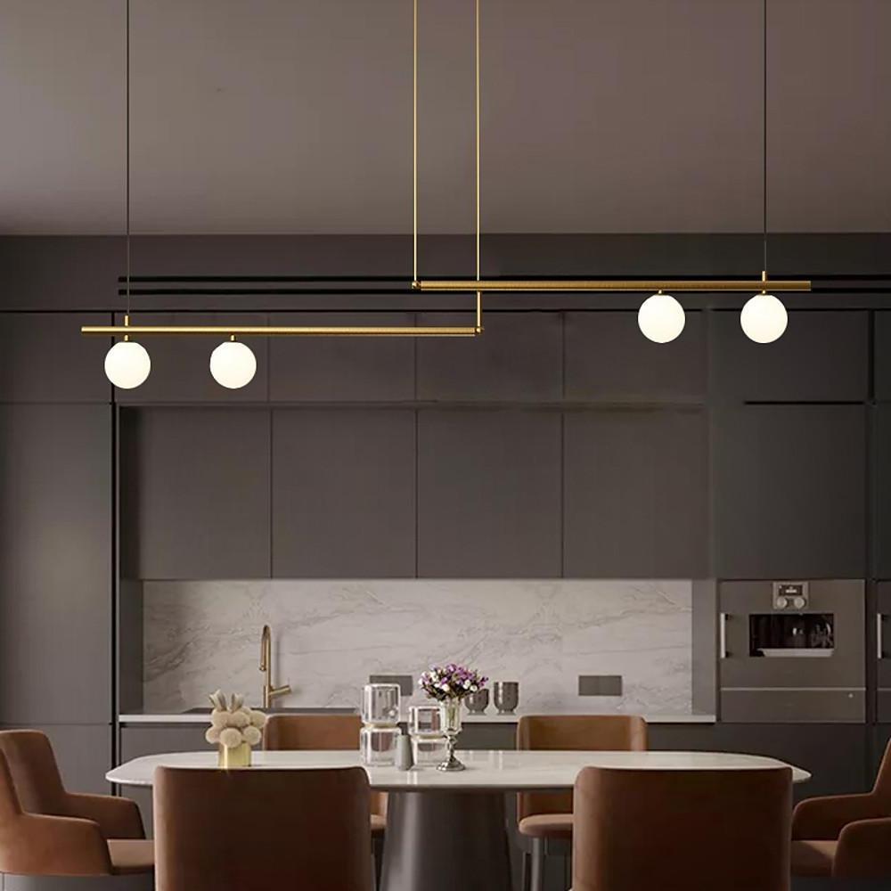 Modern gold linear pendant light hanging above dining table.