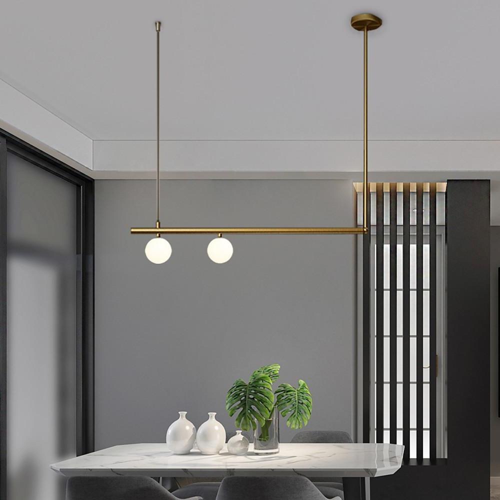 Gold linear pendant light installed in minimalist dining room.