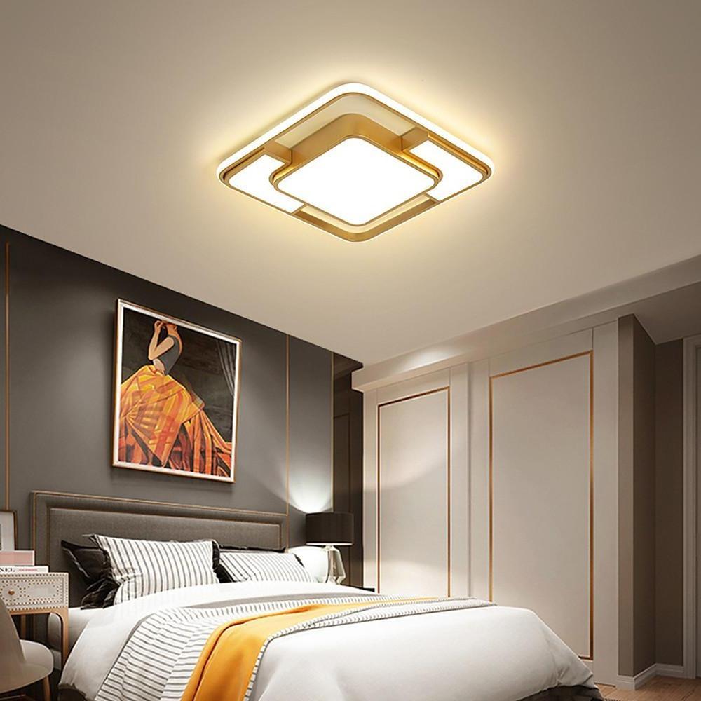 Gold square flush mount ceiling light used in a modern bedroom with accent wall