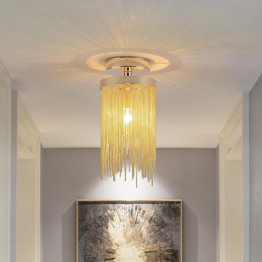 Gold tassel chandelier flush mount hanging in a gray hallway above framed wall art.