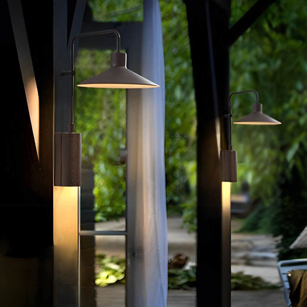 Gooseneck wall lamp lining an outdoor walkway, creating layered lighting among trees and columns.