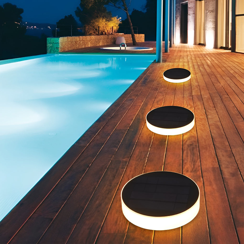 Ground solar lights providing soft illumination along a stylish stone walkway.