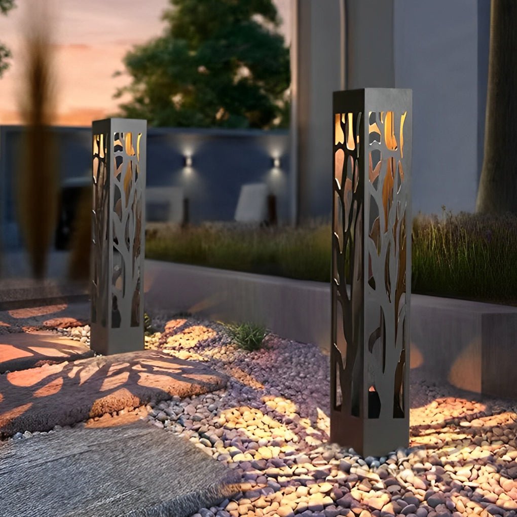 Hollow outdoor landscape lighting highlighting entryway path with decorative cutout shadows.