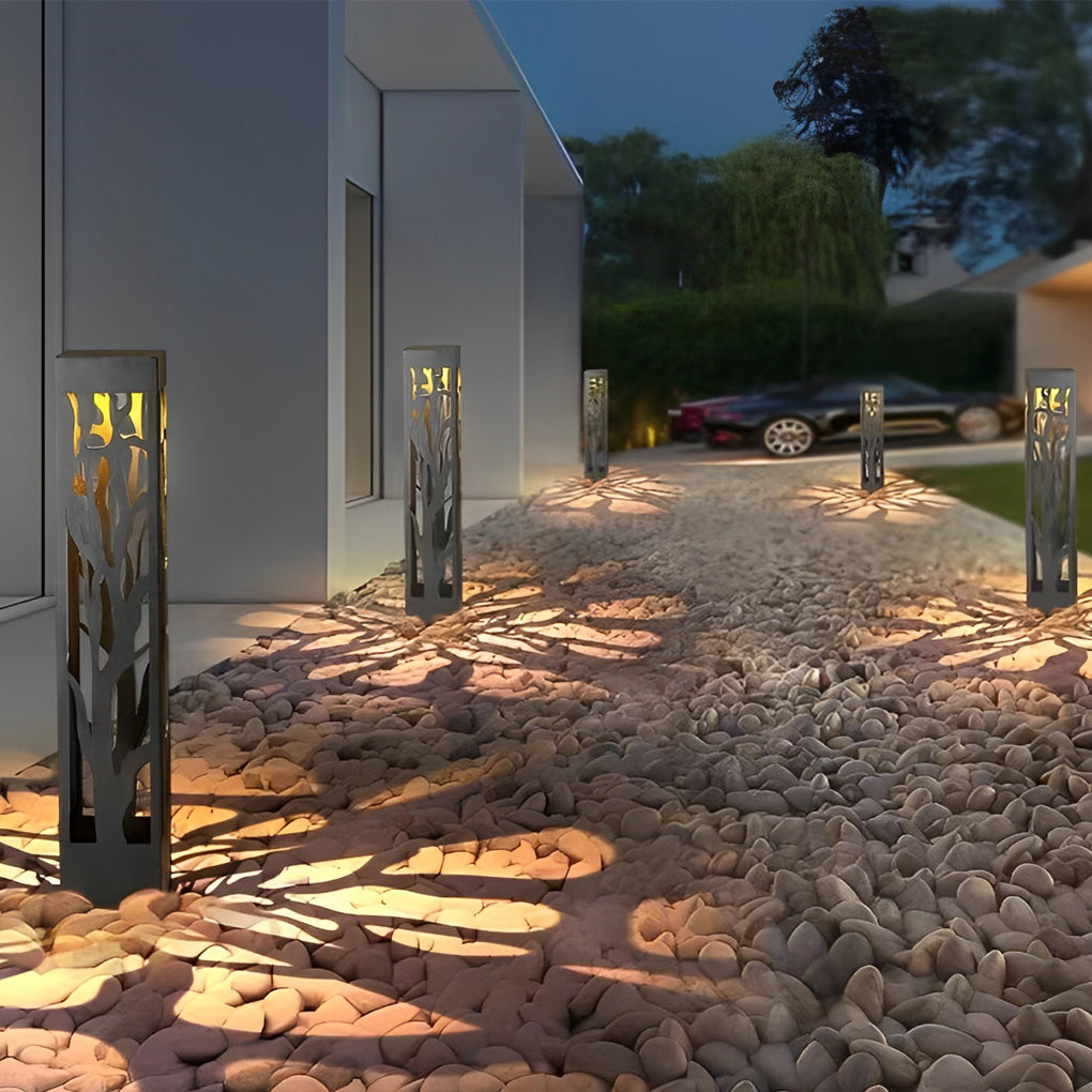 Hollow outdoor landscape lighting installed beside gravel path near residential exterior wall.