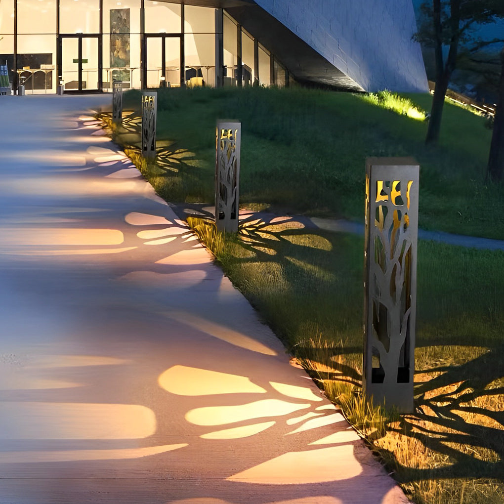 Hollow outdoor landscape lighting illuminating lawn edge beside modern building exterior.