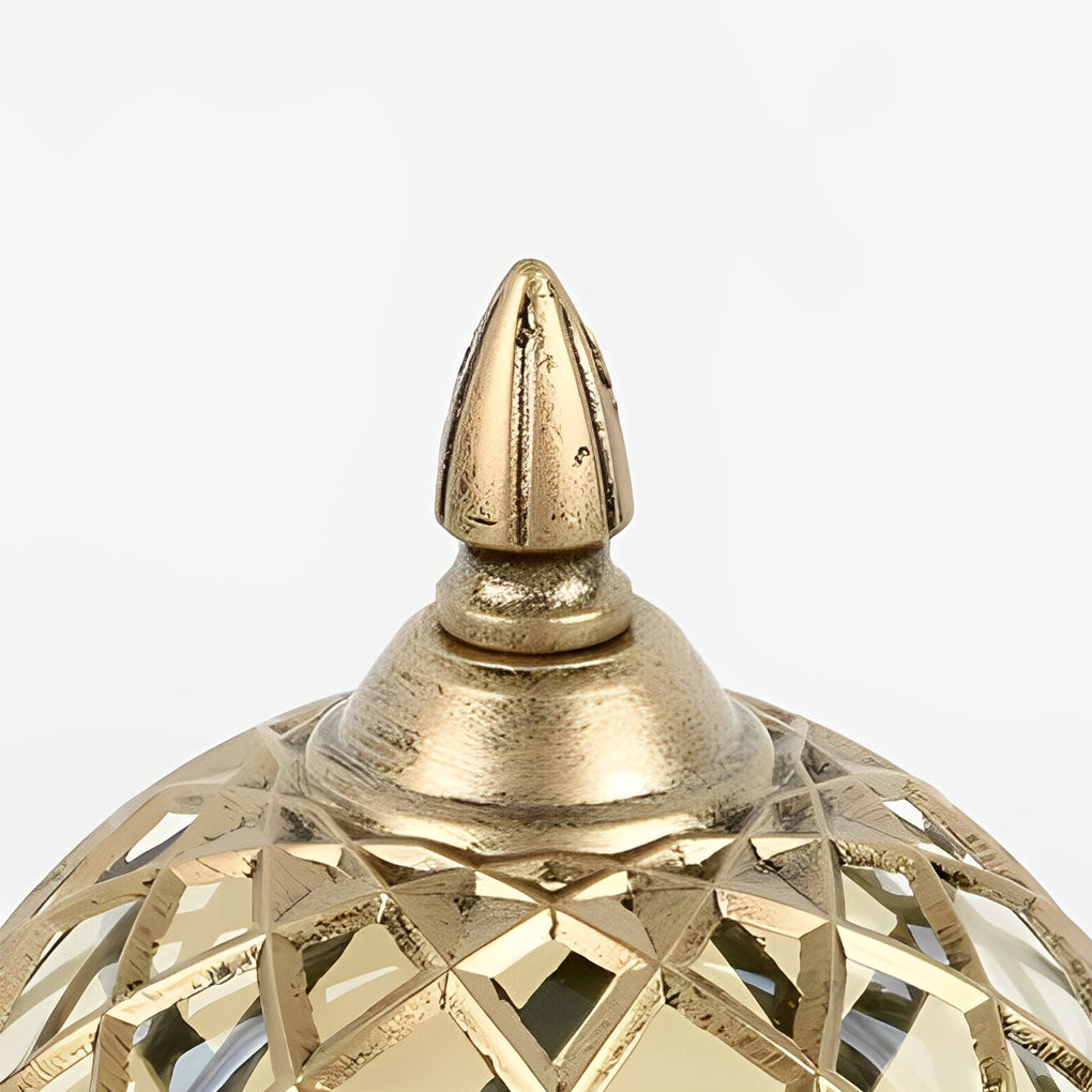 Top view of a home pillar light, focusing on the ornate gold finial and lattice pattern of the sphere.
