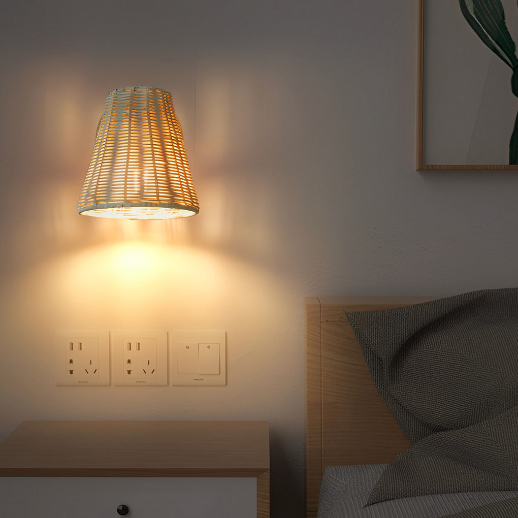 Japanese wall light with a woven rattan shade, mounted beside a bed with neutral bedding and wooden furniture.