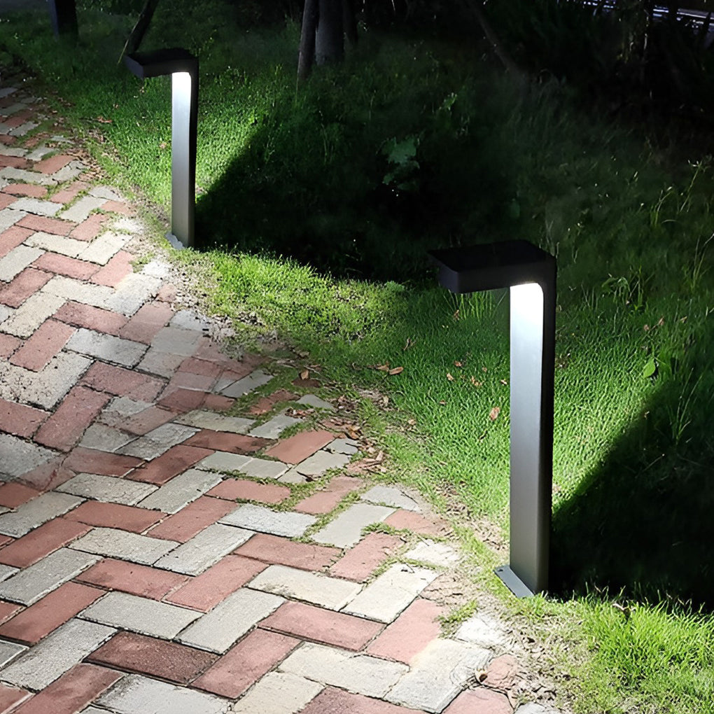 L shaped landscape light with a black finish, providing ambient light in a garden setting.